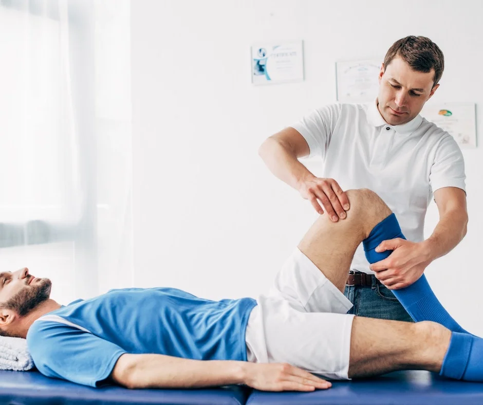 Image of a physiotherapist massaging a football player